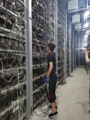 A picture of an altcoin mining farm with rows of mining rigs, highlighting the scale and infrastructure involved in the operation